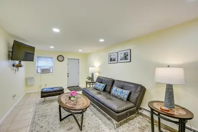 a living room with a leather couch and tables at Walk to Lincoln Park Jersey City Commuter Apt! in Jersey City