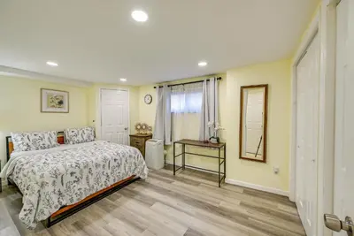 a bedroom with a bed and a table and a mirror at Walk to Lincoln Park Jersey City Commuter Apt! in Jersey City