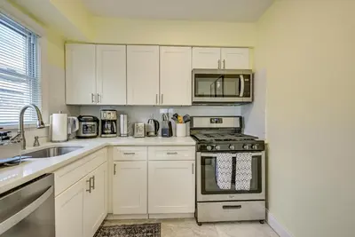 a kitchen with white cabinets and a stove top oven at 6 Mi to Lower Manhattan Pet-Friendly Apt! in Jersey City
