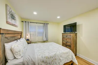 a bedroom with a bed and a flat screen tv at 6 Mi to Lower Manhattan Pet-Friendly Apt! in Jersey City
