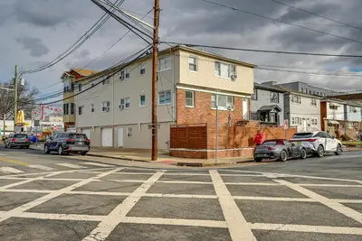 an empty street with cars parked in front of a house at 6 Mi to Lower Manhattan Pet-Friendly Apt! in Jersey City