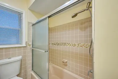 a bathroom with a toilet and a glass shower at 6 Mi to Lower Manhattan Pet-Friendly Apt! in Jersey City
