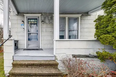 a white house with a white door and stairs at Work and Study Binghamton Apt 2 Mi to Downtown in Binghamton