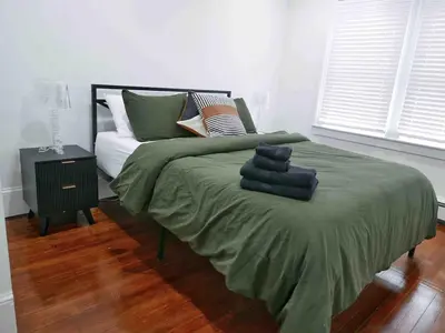a bedroom with a bed with green sheets and pillows at Private 10 guest Getaway Fire-Pit Golf Hike Ski Spa in Vernon
