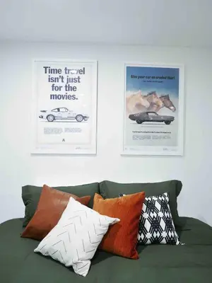 two posters on the wall above a green couch with pillows at Private 10 guest Getaway Fire-Pit Golf Hike Ski Spa in Vernon