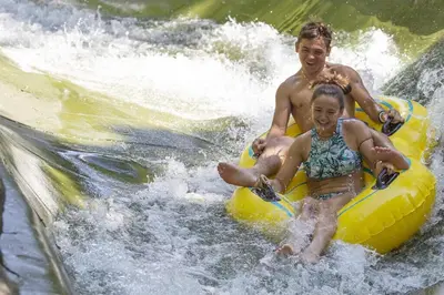 a man and a girl on a raft in the water at Luxe 10 guest Ski Cabin - Snowboarding Hiking Pools Golf Tennis in Vernon Township