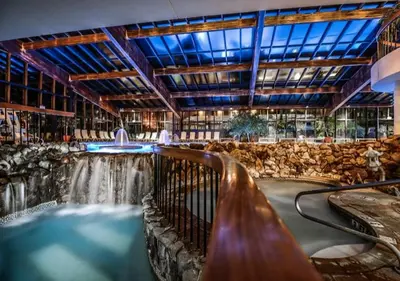a swimming pool with a waterfall in a building at Luxe 10 guest Ski Cabin - Snowboarding Hiking Pools Golf Tennis in Vernon Township