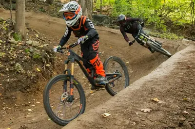 two people riding bikes on a dirt road at Luxe 10 guest Ski Cabin - Snowboarding Hiking Pools Golf Tennis in Vernon Township