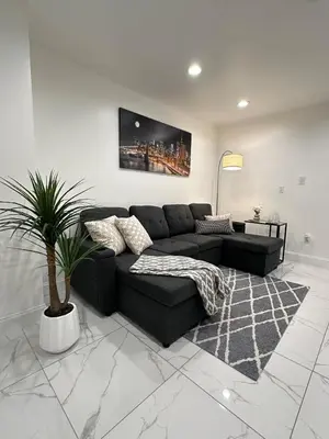 a living room with a black couch and a potted plant at Luxury escape near New York City in Weehawken