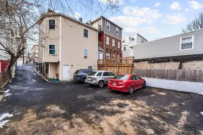 two cars parked in a parking lot in front of a house at Modern 2BR, King Suite and Free Parking, 30min to NYC in Newark