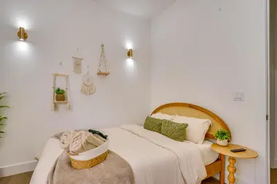 a white bedroom with a bed and a table at 5 Mi to NYC Bright and Chic Jersey City Getaway! in Jersey City