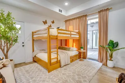 a bedroom with bunk beds and a living room at 5 Mi to NYC Bright and Chic Jersey City Getaway! in Jersey City