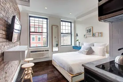a bedroom with a bed and a tv in a room at East Village by Vibe I in New York