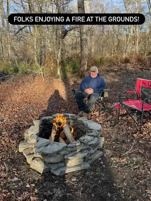 a man sitting in front of a fire pit at Live The Outdoors