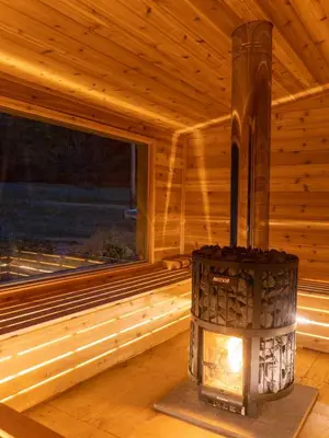 a fireplace in a wooden cabin with a window at LaValleyEstates in Long Eddy