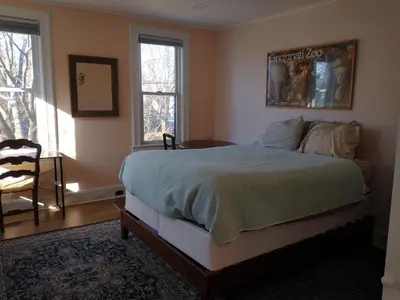 a bedroom with a bed and a chair and windows at 3 Bedroom Apartment 30 Minutes to New York No Car Needed in Ridgefield Park