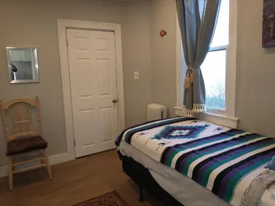 a bedroom with a bed and a window and a chair at 3 Bedroom Apartment 30 Minutes to New York No Car Needed in Ridgefield Park