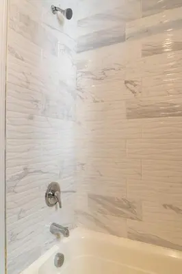a bathroom with a tub and a shower with tiles at Spacious 3BR Home Near Newark Airport in Newark