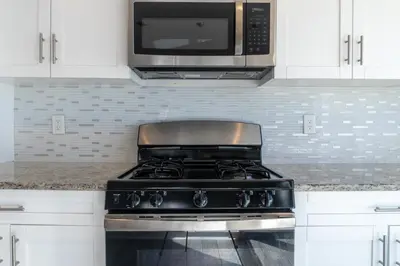 a stove in a kitchen with a microwave at Spacious 3BR Home Near Newark Airport in Newark