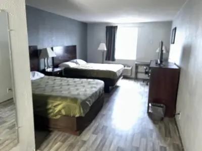 a hotel room with two beds and a desk at Economy Inn of Reading in Reading