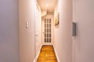 a hallway with white walls and a wooden floor at Prestige Gramercy Park Suites in New York