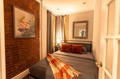 a bed in a room with a brick wall at Prestige Gramercy Park Suites in New York
