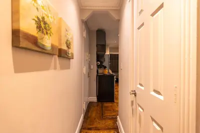 a hallway with a door and paintings on the walls at Prestige Gramercy Park Suites in New York