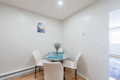 a dining room with a blue table and white chairs at Modern 2BR 8 mins to Penn Station with WiFi and Laundry in Newark