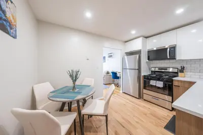 a kitchen and dining room with a table and chairs at Modern 2BR 8 mins to Penn Station with WiFi and Laundry in Newark