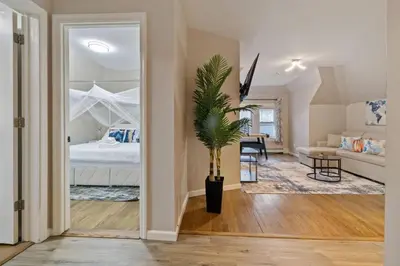 a living room with a bed and a potted plant at Modern 2BR Near NYC with Free Parking and Workspace in East Orange