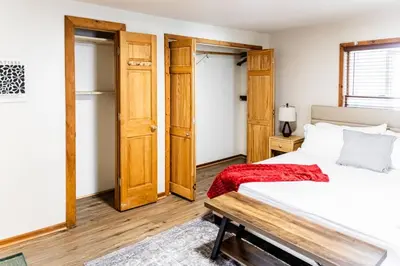 a bedroom with a bed and a wooden door at Charming 2 Bedroom Apartment Near NYC, Metlife Stadium in Hackensack