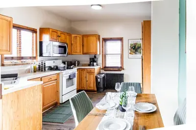 a kitchen with wooden cabinets and a table with chairs at Charming 2 Bedroom Apartment Near NYC, Metlife Stadium in Hackensack