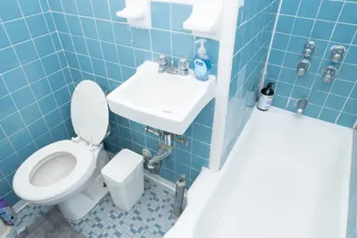 a blue tiled bathroom with a toilet and a sink at Elegant84 West Side Home 5 min to Central Park in New York