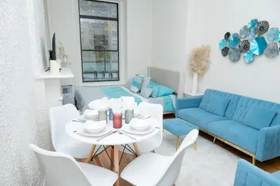 a living room with a table and a blue couch at Elegant84 West Side Home 5 min to Central Park in New York