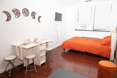 a bedroom with a bed and a desk with stools at West47 Village Getaway - Subway & Local Cafés in New York