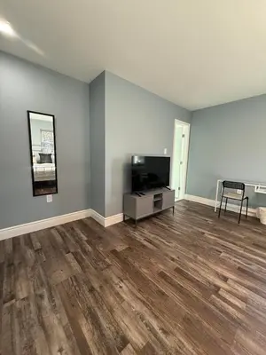an empty living room with a television and wooden floors at New house close to Fairmount Park in Philadelphia