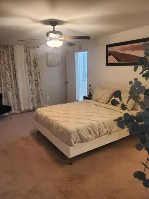 a bedroom with a bed and a ceiling fan at The Carneys Point Cottage