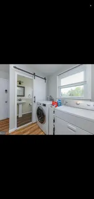 a kitchen with a washing machine and a window at The Carneys Point Cottage