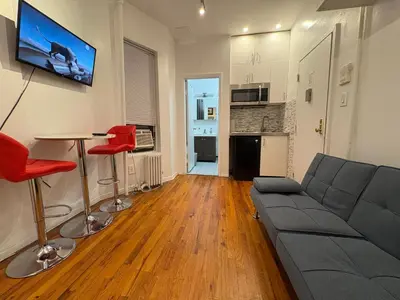 a living room with a couch and a table at Hudson Crown Suites in New York