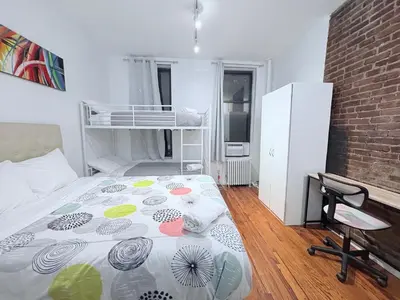 a bedroom with a bed and a refrigerator at Hudson Crown Suites in New York