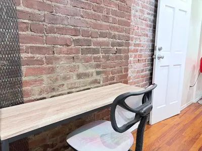 a black chair sitting next to a brick wall at Hudson Crown Suites in New York