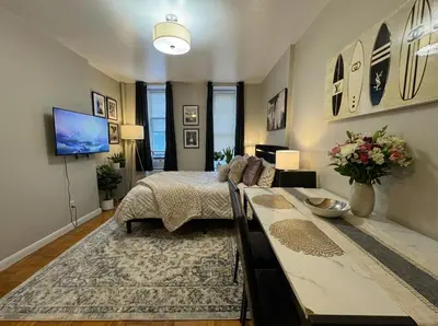 a bedroom with a bed and a table in it at Hudson Crown Suites in New York