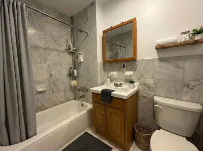 a bathroom with a sink and a toilet and a bath tub at Hudson Crown Suites in New York