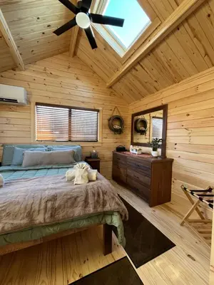 a bedroom with a bed and a ceiling fan at Private Luxury Log Cabin in the Endless Mountains, Firepit, Farm Charm in Kingsley