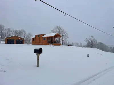 a house in the snow with a parking meter at Private Luxury Log Cabin in the Endless Mountains, Firepit, Farm Charm in Kingsley