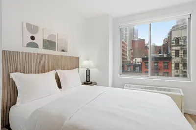 a white bedroom with a large bed and a window at The Aurora in New York