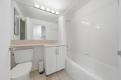 a white bathroom with a toilet and a sink at The Aurora in New York