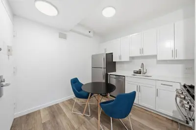 a kitchen with a black table and blue chairs at The Aurora in New York