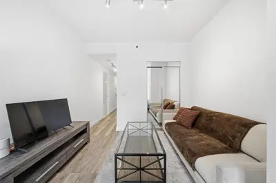 a living room with a couch and a flat screen tv at The Aurora in New York