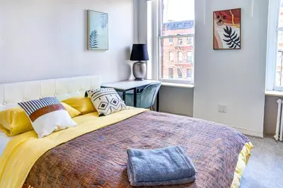 a bedroom with a large bed with a yellow blanket at 4 BD Family Unit in Central Location in New York
